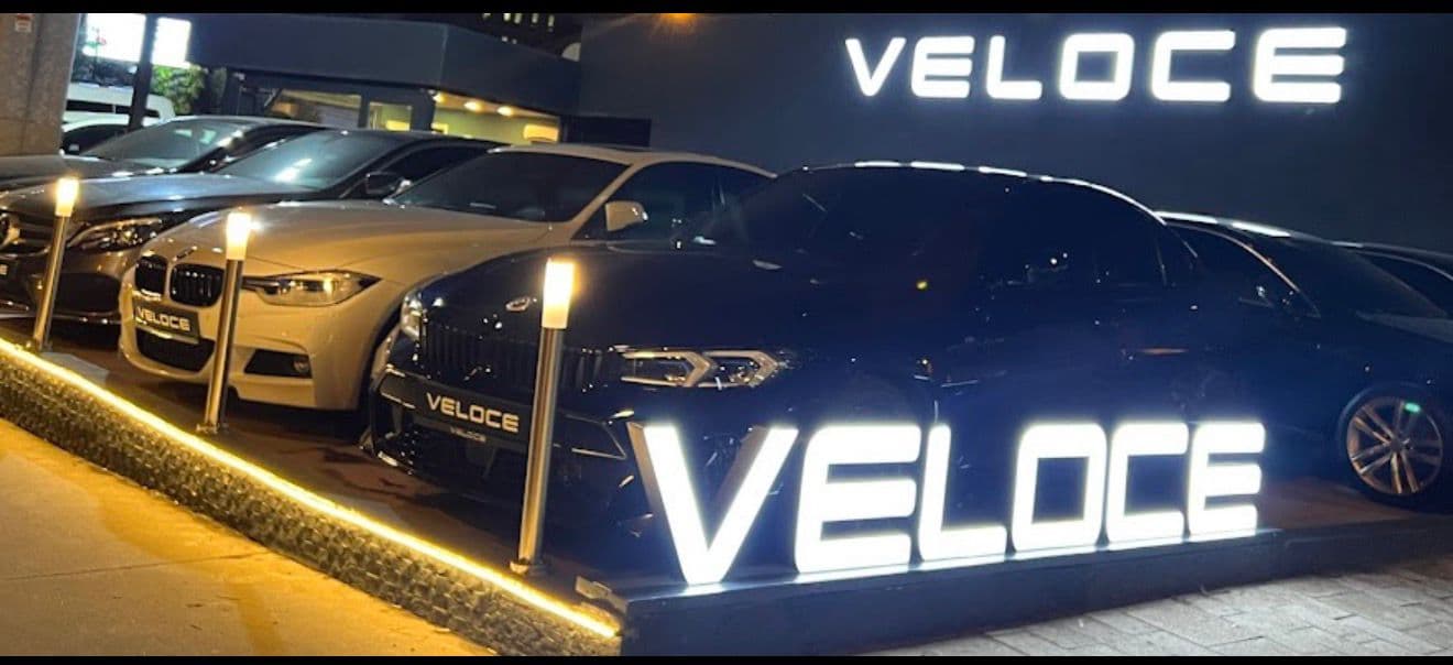 Mesudiye Otomotiv — gece ışıklı tabela ve premium araçlar